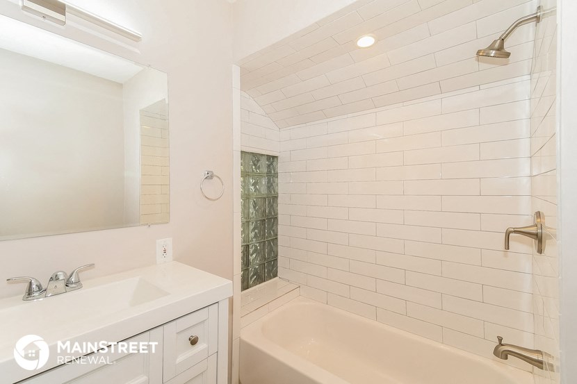 a bathroom with a tub and a sink and a mirror