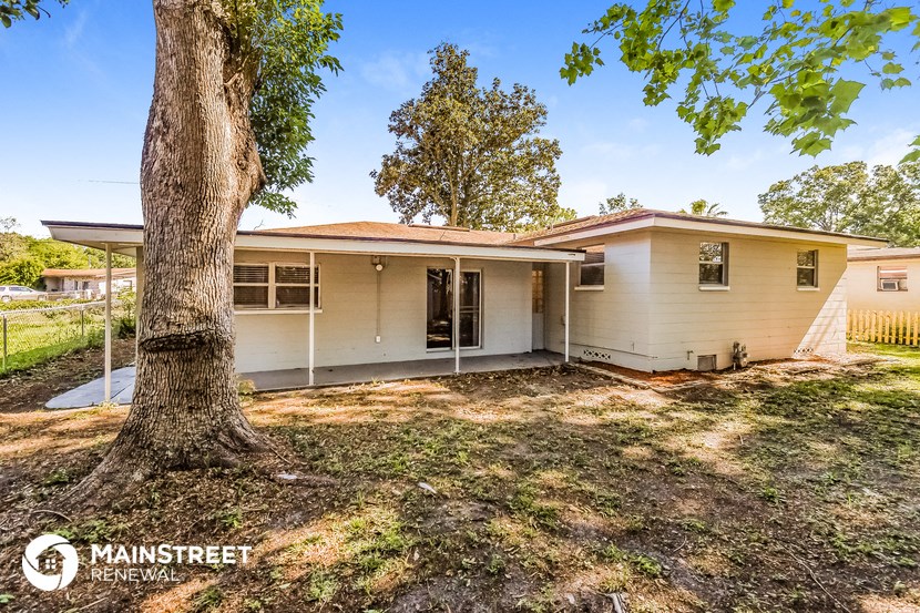 a white house with a tree in the yard