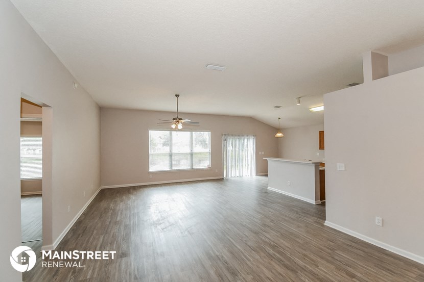 the living room and kitchen of an empty house