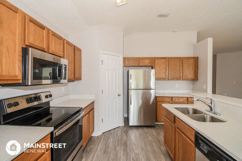 a kitchen with wooden cabinets and stainless steel appliances