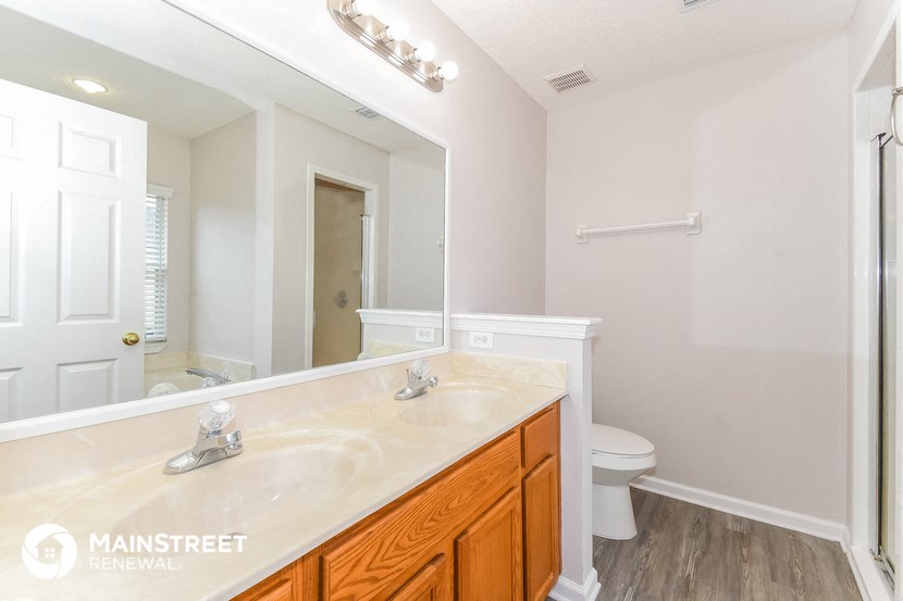 a bathroom with a large mirror and a sink and a toilet