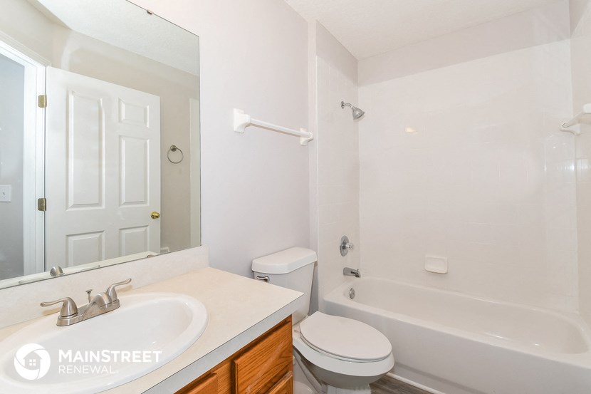 a bathroom with a sink toilet and a tub and a mirror