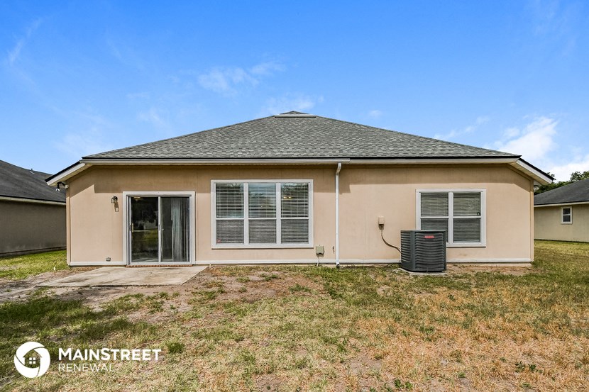 the exterior of a house with a yard and a trash can