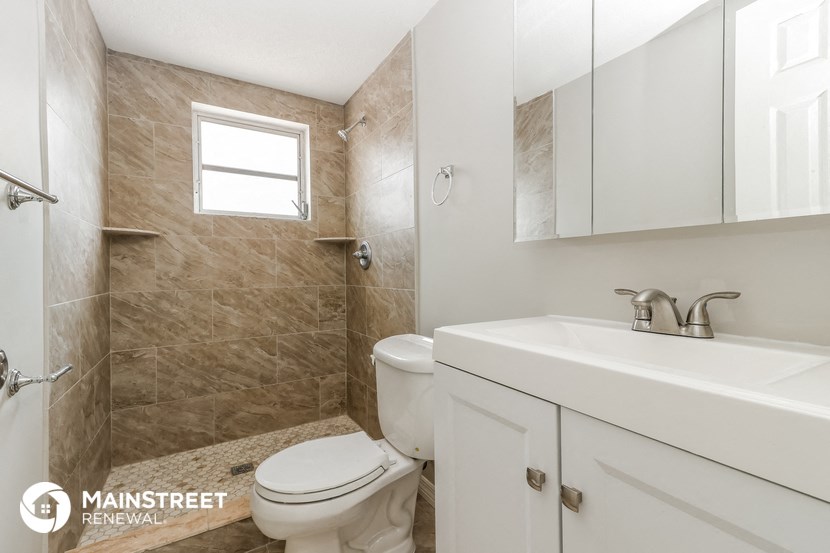 a bathroom with a toilet and a sink and a shower