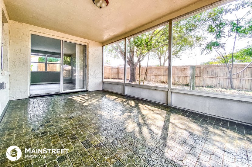 an empty living room with large windows and a patio