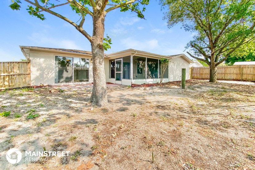 a house with a yard and trees in front of it