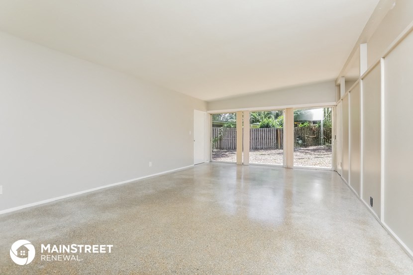 a large empty living room with white walls and a concrete floor