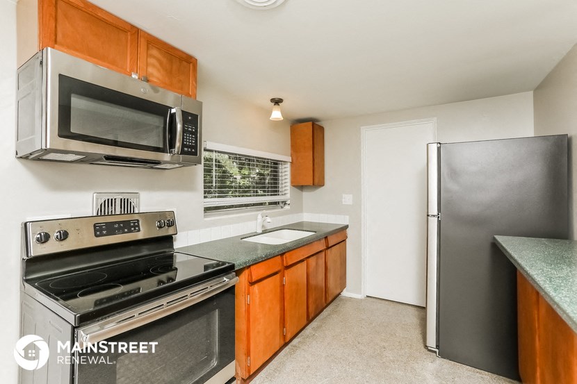 a kitchen with stainless steel appliances and a refrigerator