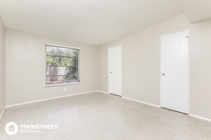 an empty living room with a window and a door
