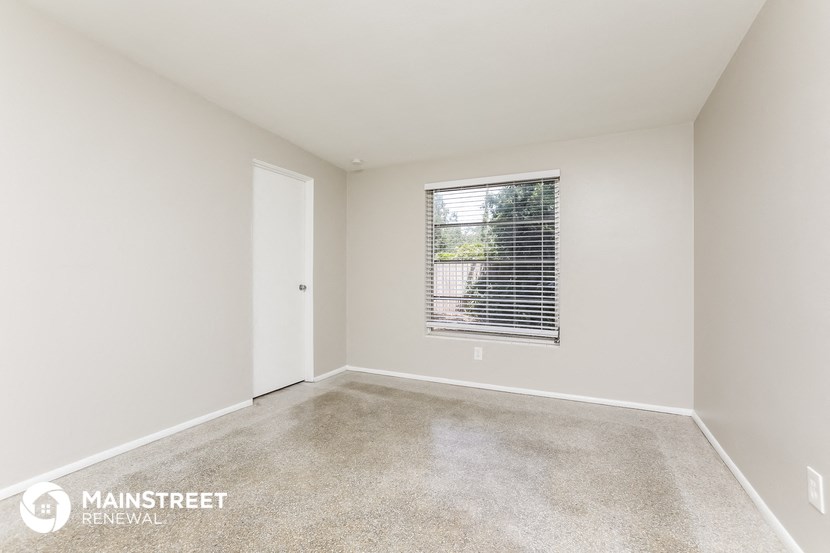 an empty room with a window and a door