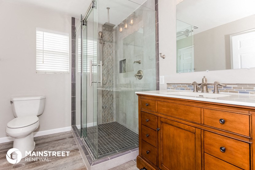 a bathroom with a toilet and a shower and a sink