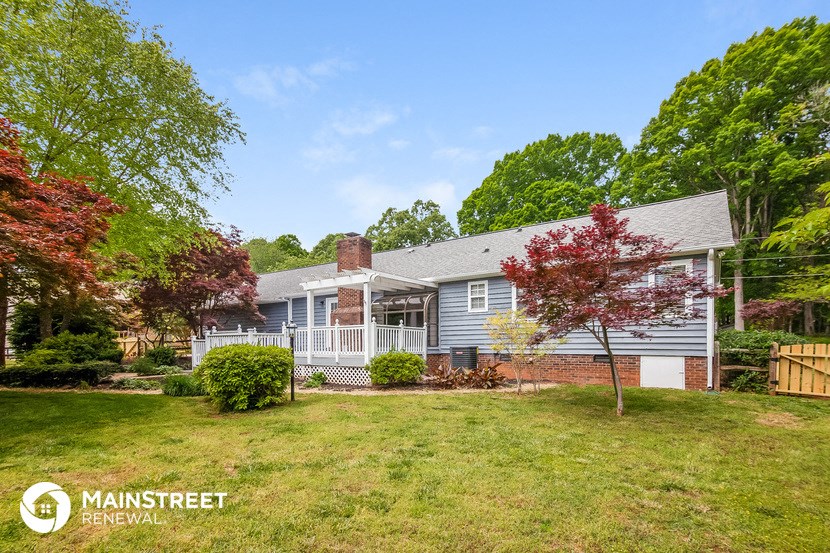 a blue house with a yard and a white fence