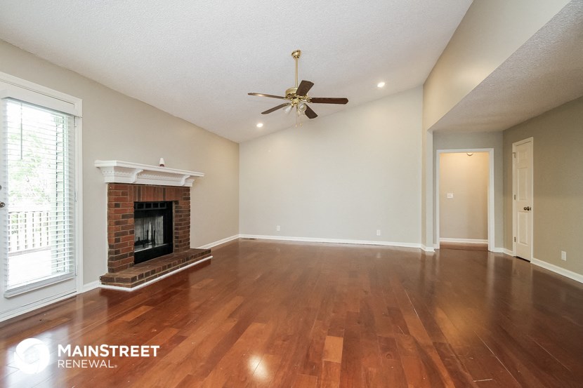 the living room with wood flooring and fireplace