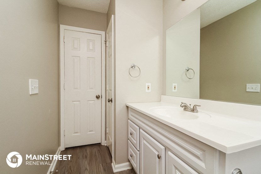 a bathroom with a sink and a mirror and a door