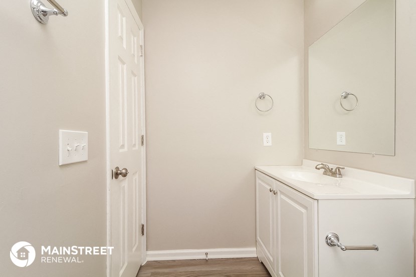 a bathroom with a sink and a mirror and a door