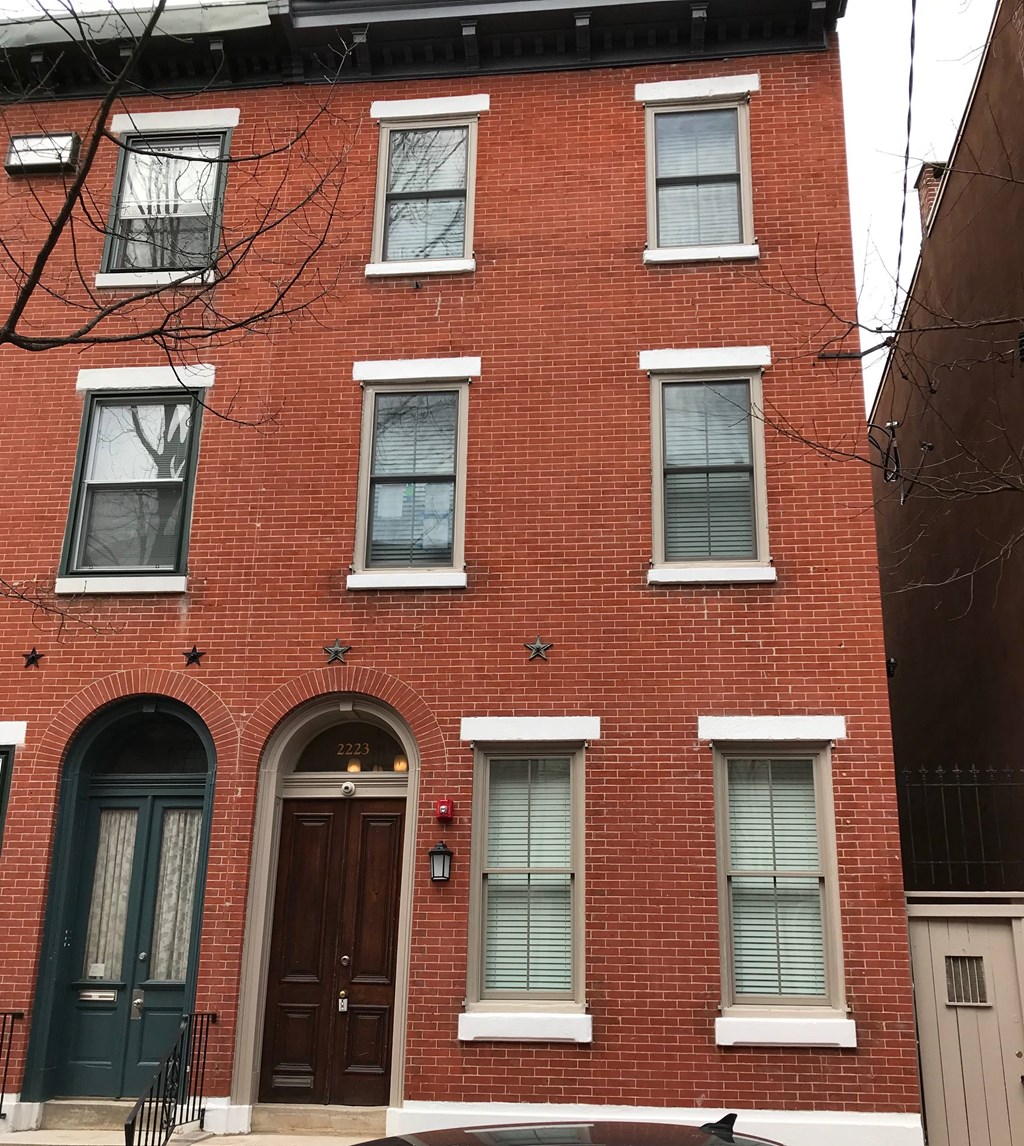 a red brick house with a black door and windows