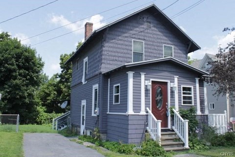 A blue house with a red door and white steps.