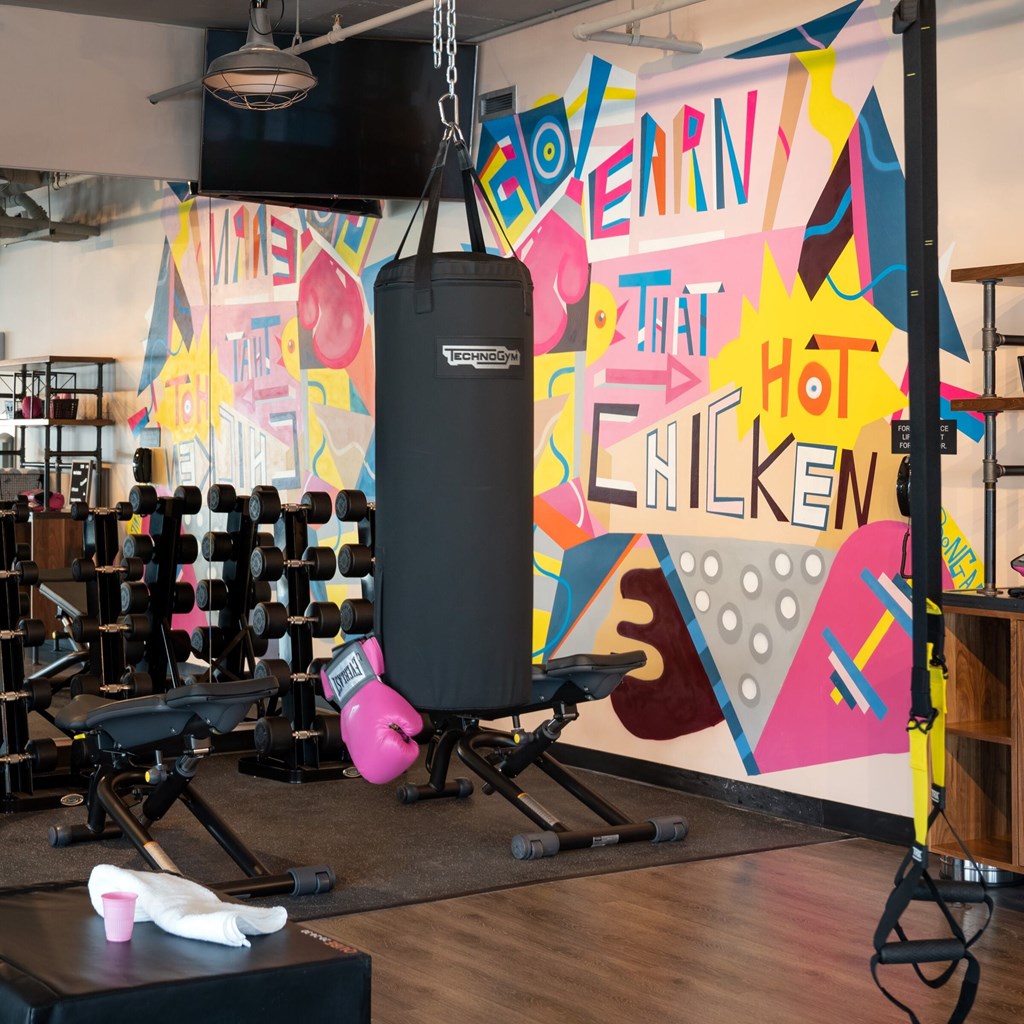 A gym with a punching bag and weights.