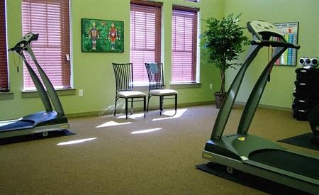 a gym room with two machines and a table and chairs