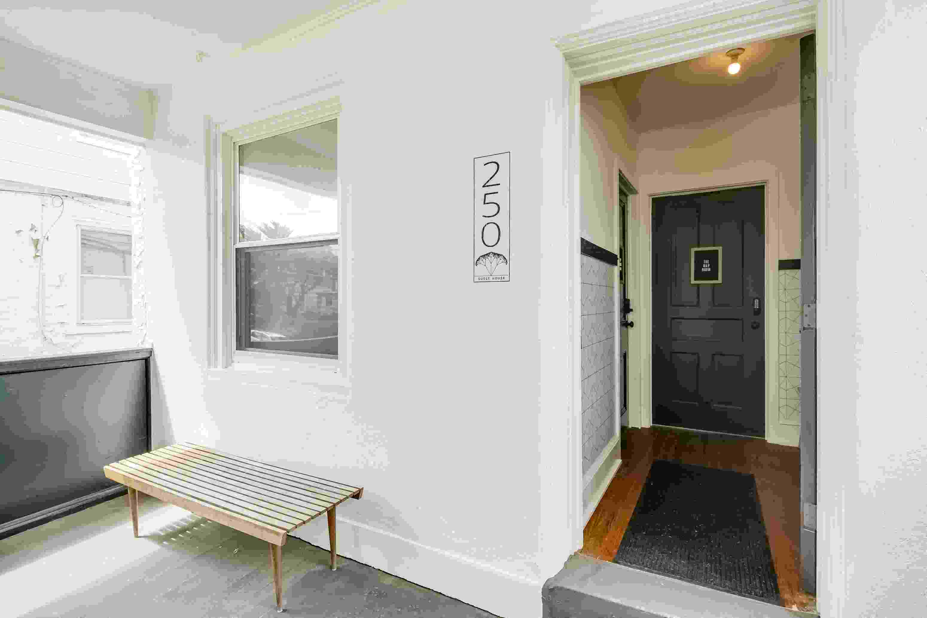 the front entrance of a building with a bench and a black door