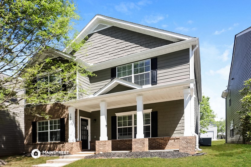 a house with a gray roof and a white porch