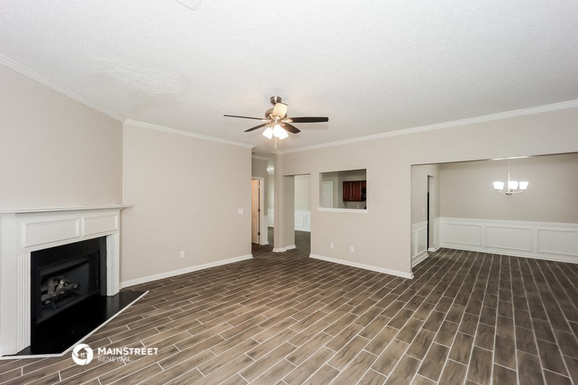 a living room with a fireplace and a ceiling fan