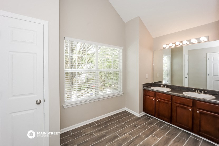 the master bathroom of a home with two sinks and a large window