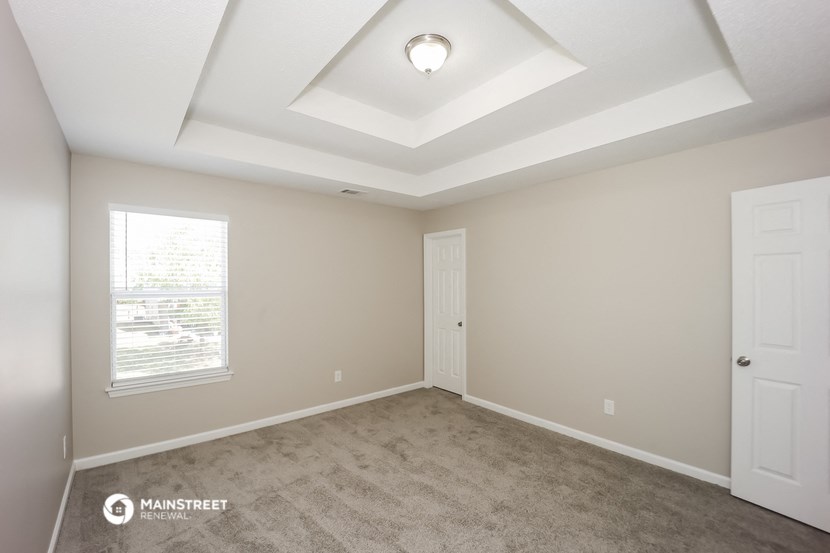 the spacious living room with carpeting and a coffered ceiling