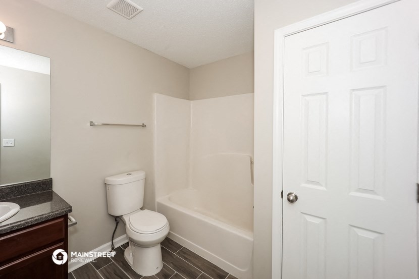 a bathroom with a toilet and a shower and a sink