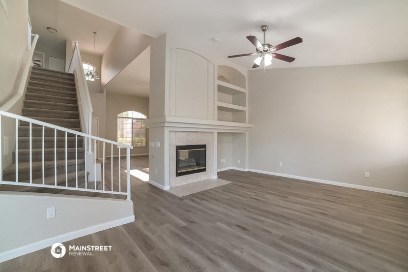 an empty living room with a fireplace and stairs