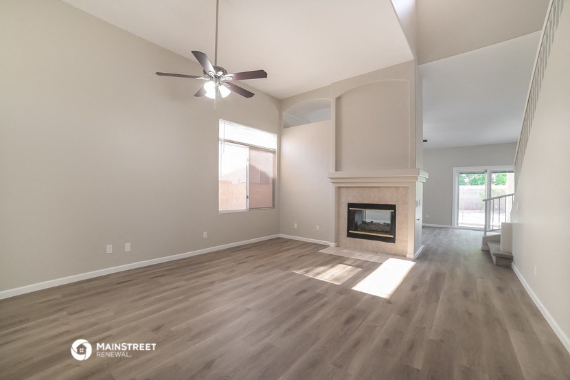the living room with fireplace and ceiling fan