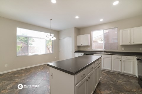 the kitchen of a new home with white cabinets and a black counter top