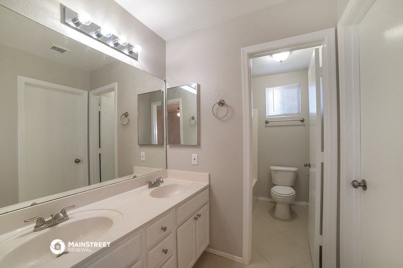 a bathroom with a large mirror and a sink and a toilet