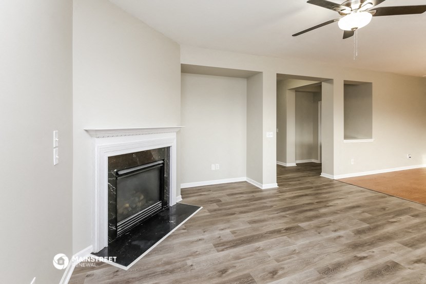 the living room of an empty house with a fireplace