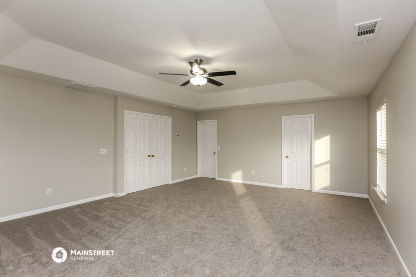 an empty living room with a ceiling fan