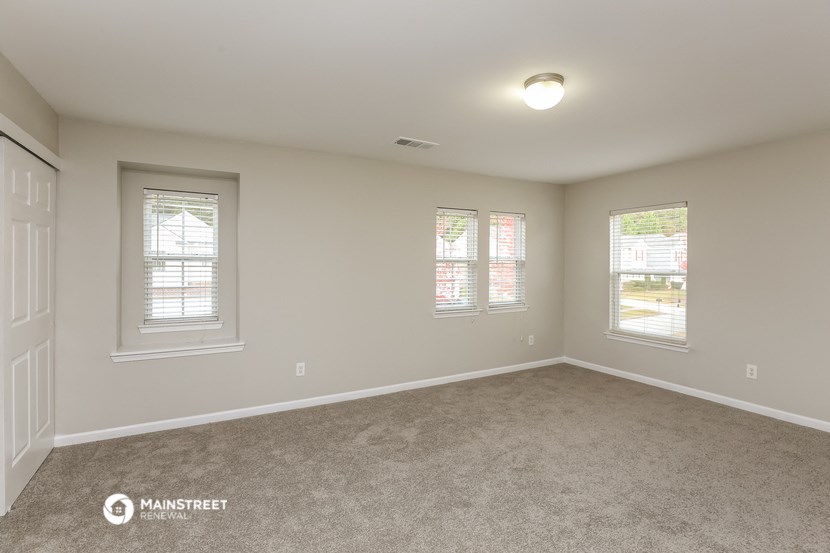 the spacious living room of a manufactured home with windows and carpet