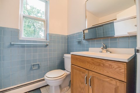 a bathroom with a toilet and a sink and a window