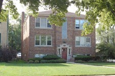 A red brick building with a white door and windows.