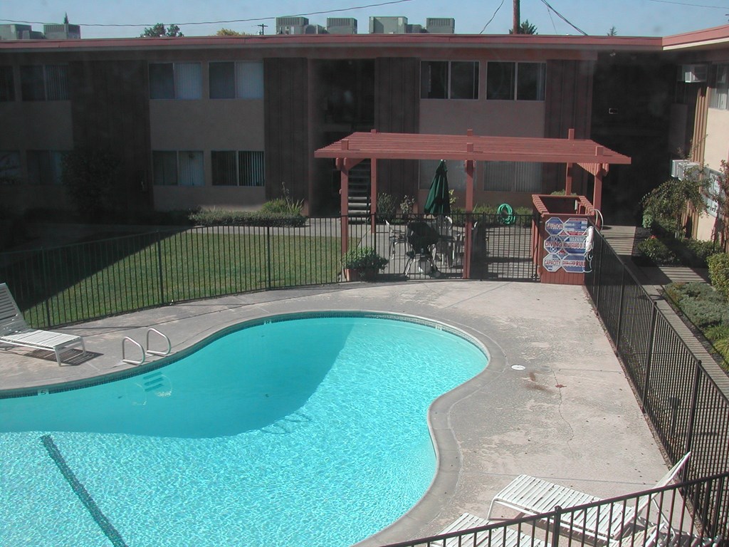 a swimming pool in front of a house with a pool