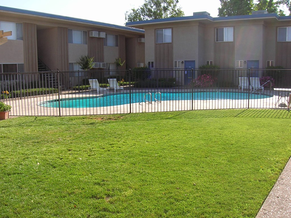 a large swimming pool in front of an apartment building