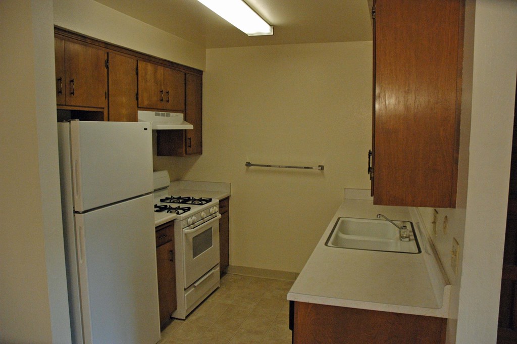 a kitchen with white appliances and a sink and a refrigerator