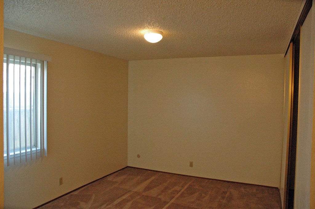 an empty room with a window and a light on the ceiling