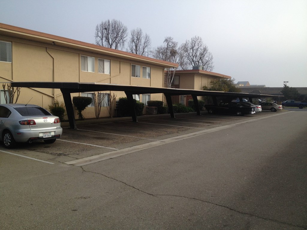 a parking lot with cars parked in front of a building