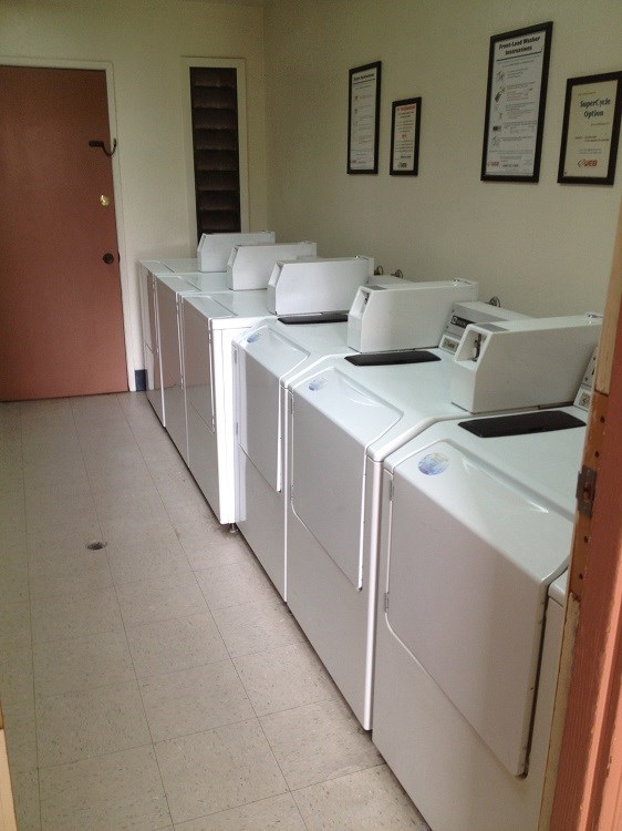 a row of white washing machines in a room