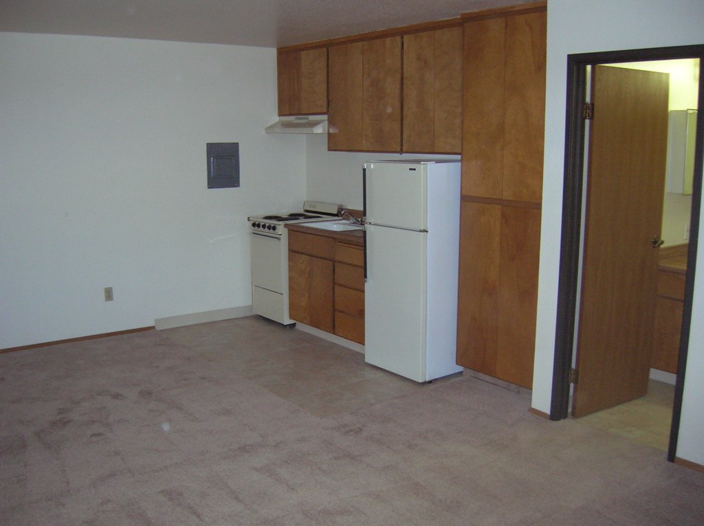 an empty kitchen with a refrigerator and a stove in it