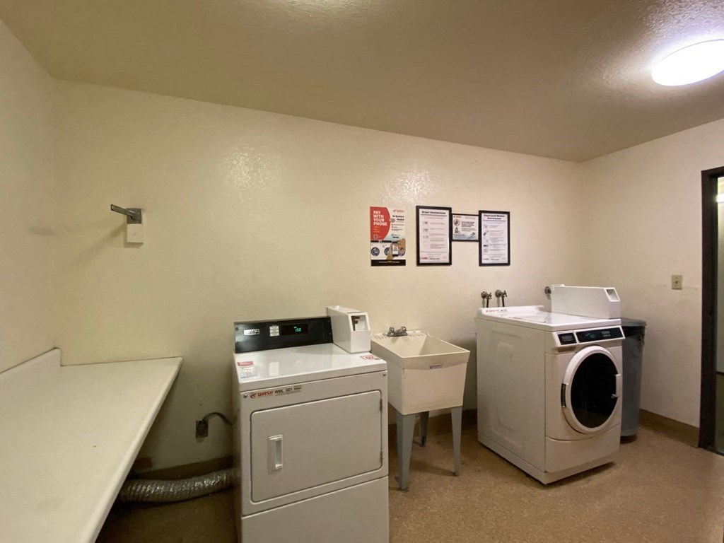a laundry room with two washers and a sink and a washing machine