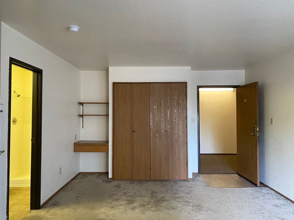 a living room with a closet and a door to a hallway