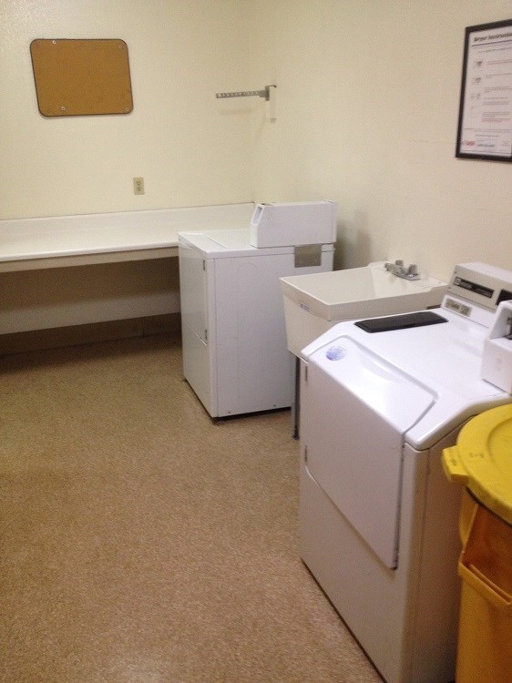 two white washing machines in a room with a sink