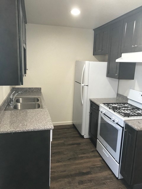 a kitchen with white appliances and a sink and a refrigerator