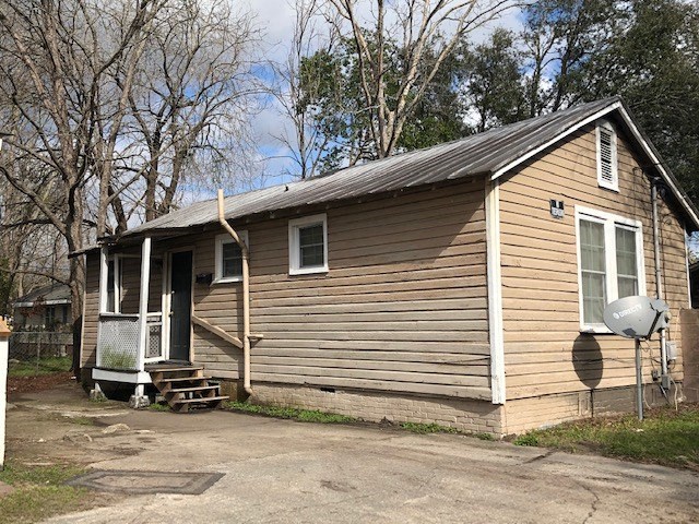 A small house with a porch and a mailbox on the right side.